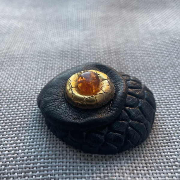 Ādas broša ar dzintaru