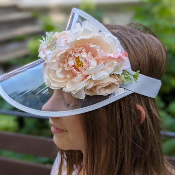Stilīgs saules cepure ar ziedu dekoru.