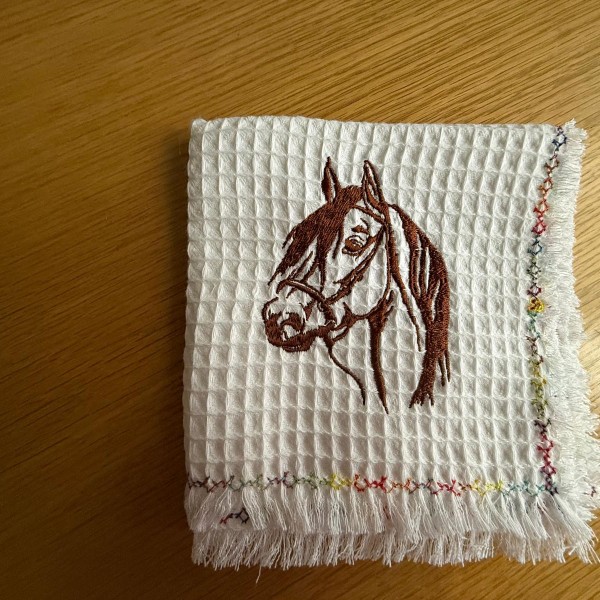 Izšūts virtuves divelis no kokvilnas vafeļauduma.