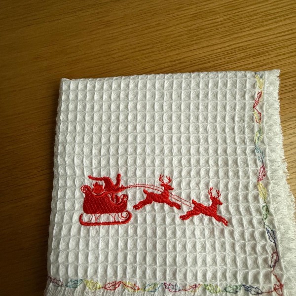 Izšūts virtuves divelis no kokvilnas vafeļauduma.