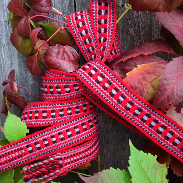 Galgauskas tautiskā ziedainā josta sarkanā, tumši brūnā un zilpelēkā krāsu gammā.