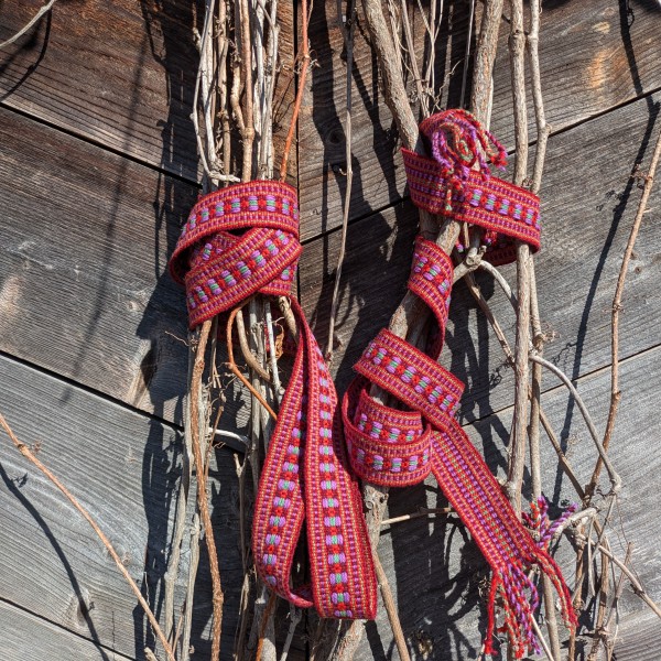 Dzērbenes  tautiskā ziedainā josta sarkanā, violētā, bāli zaļāq krāsā.