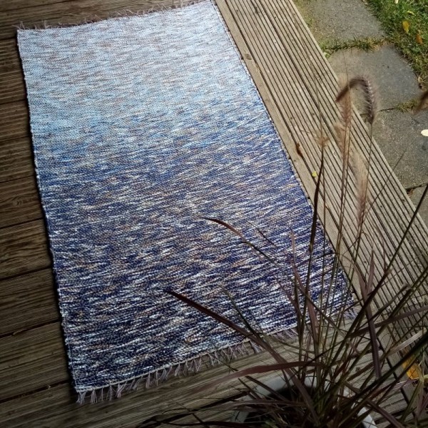 Zili balts paklājiņš